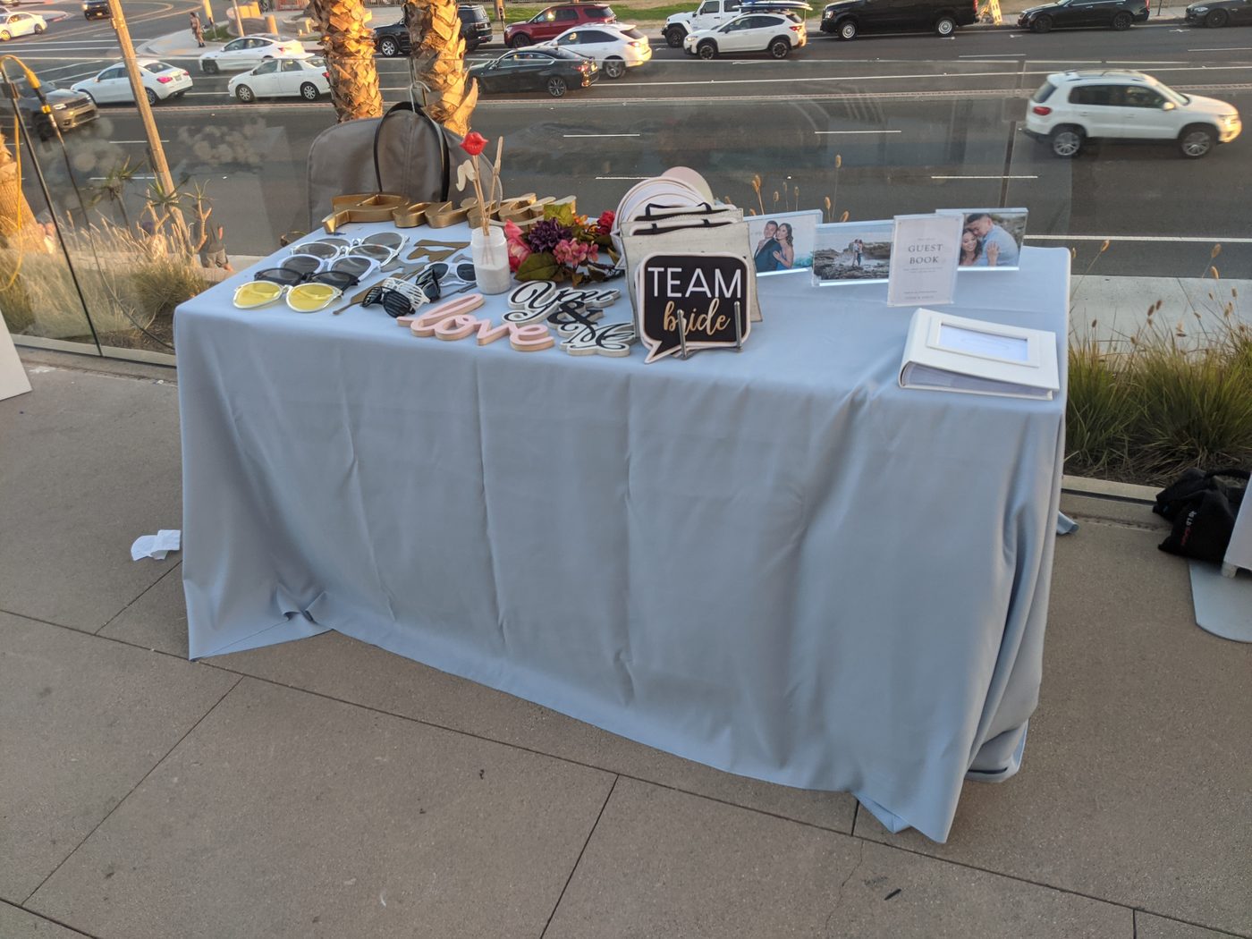 Photobooth prop table with a 'Team Bride' sign and guest book at a rooftop wedding