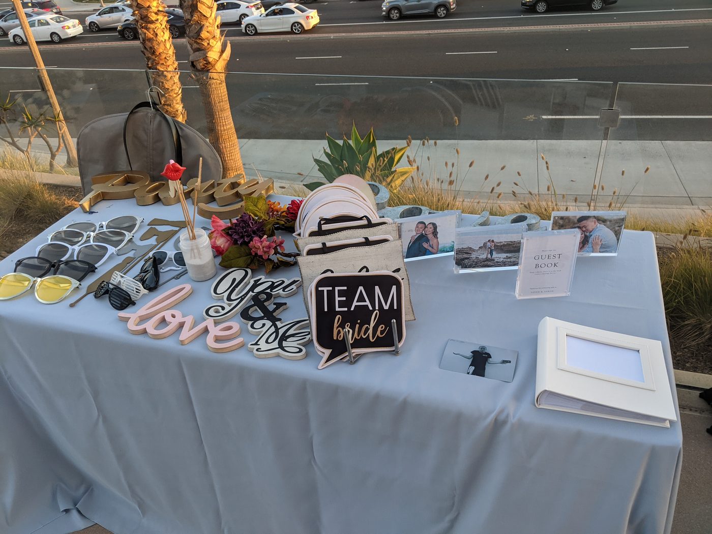 Photobooth prop table with wedding sign props and florals at a rooftop reception