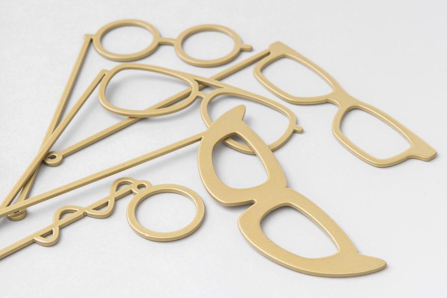 Gold glasses-on-sticks and fun sign photobooth props styled on a table