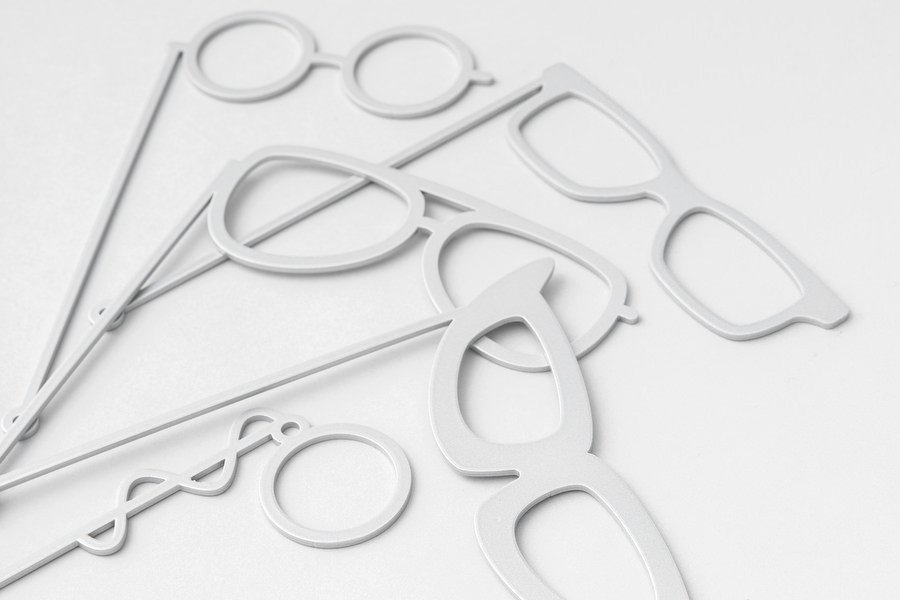 Silver and white glasses-on-sticks photobooth props styled on a table